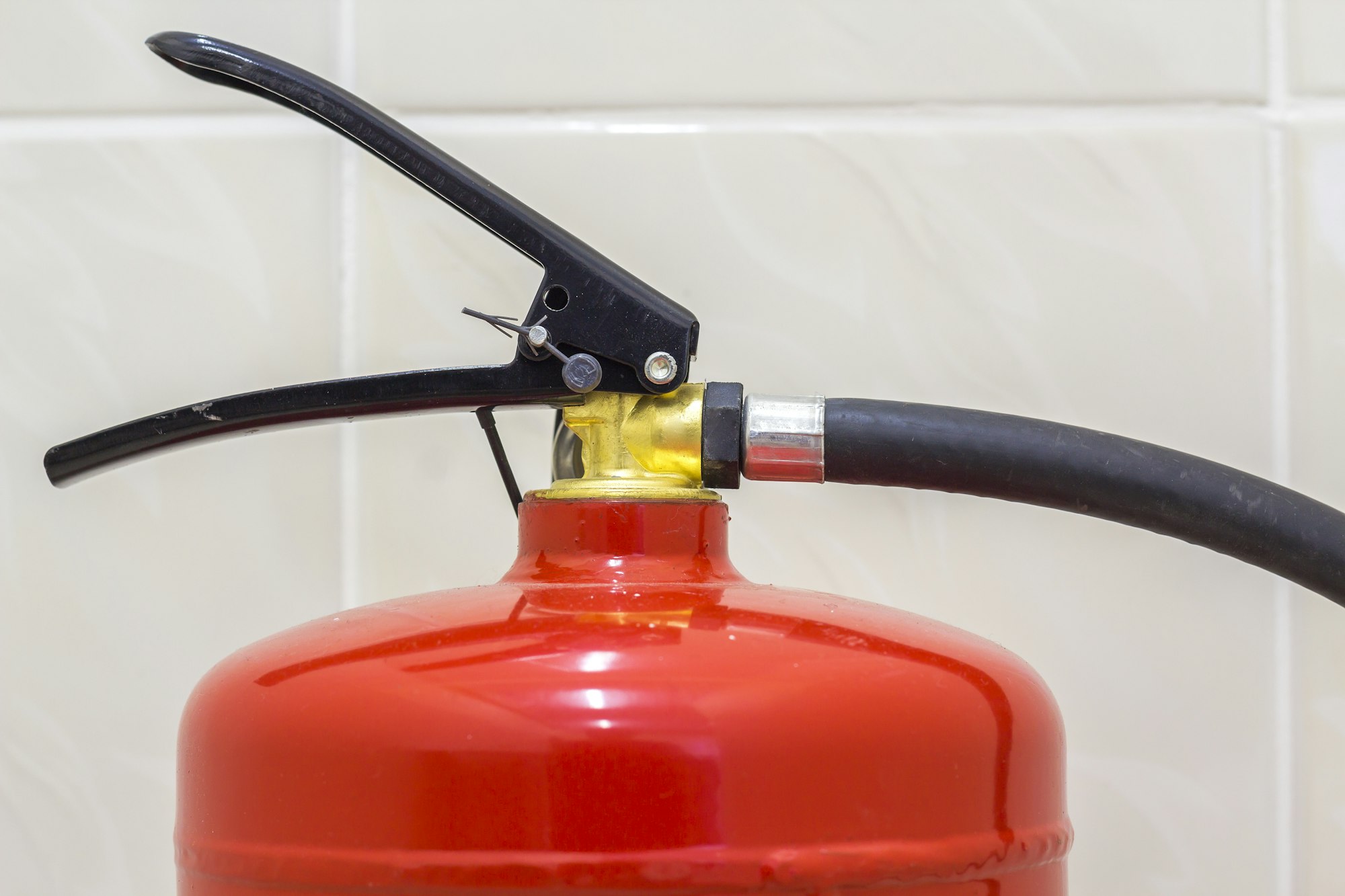 Fire extinguisher bright red isolated on white light tiles walls and floor